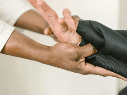 A clinician gently holding an older adult’s hands